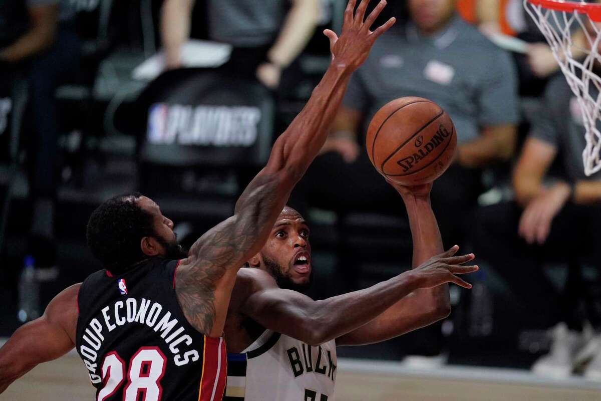 Milwaukee Bucks' Khris Middleton shoots past Miami Heat's Andre Iguodala during the second half of an NBA conference semifinal playoff basketball game Sunday, Sept. 6, 2020, in Lake Buena Vista, Fla. (AP Photo/Mark J. Terrill)
