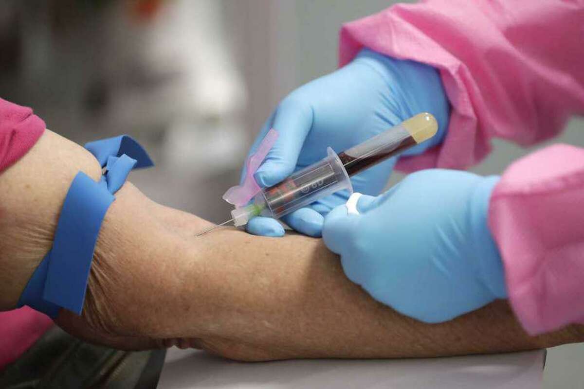 In this Tuesday, May 5, 2020 file photo, a health worker draws blood from a patient for a COVID-19 coronavirus antibody test in DeLand, Fla. Scientists are still working to figure out how well antibodies for the new coronavirus may shield someone from another infection, or how long that protection might last.