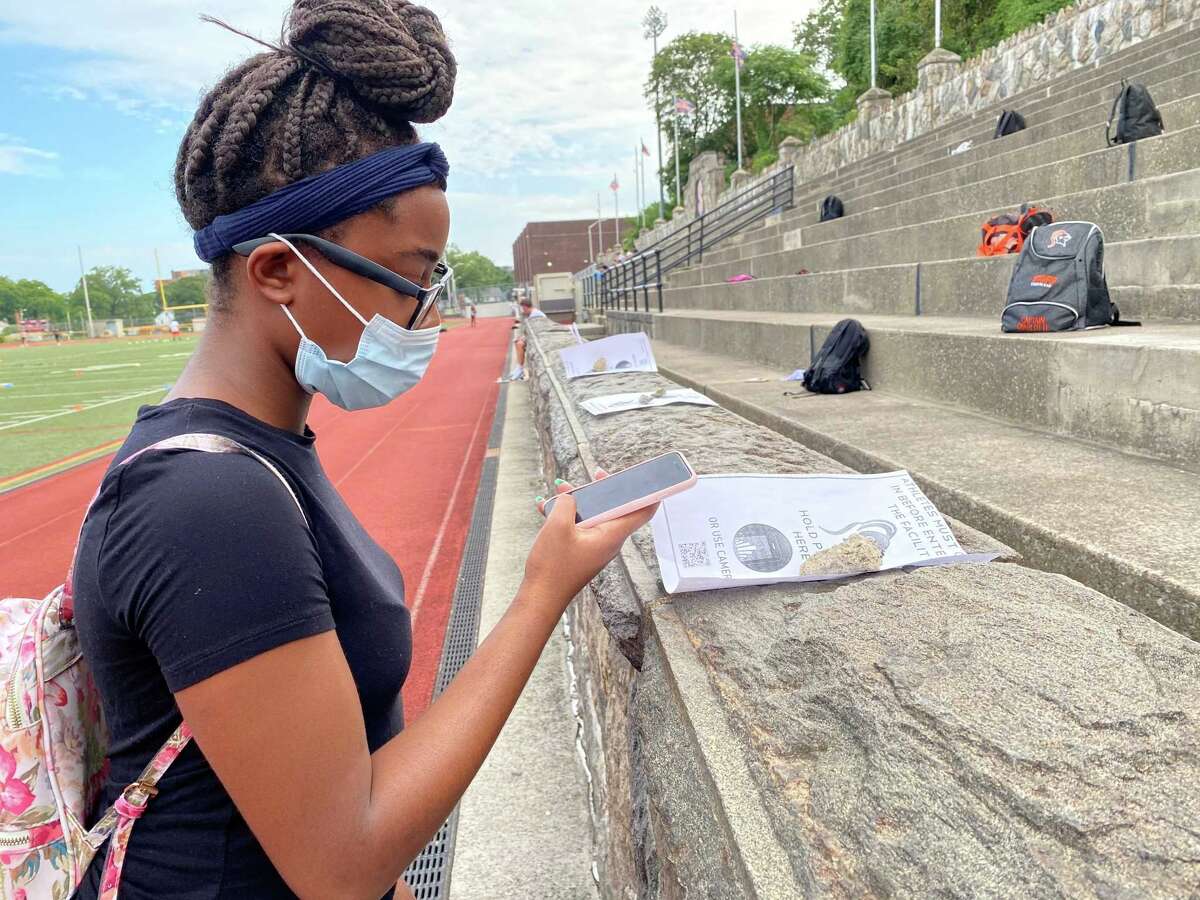Stamford freshman cheerleader Aniya Exantus checks in on her phone with a QR code to be medically cleared to begin practice at Boyle Stadium in Stamford, Conn. on Thursday, Sept. 3, 2020.