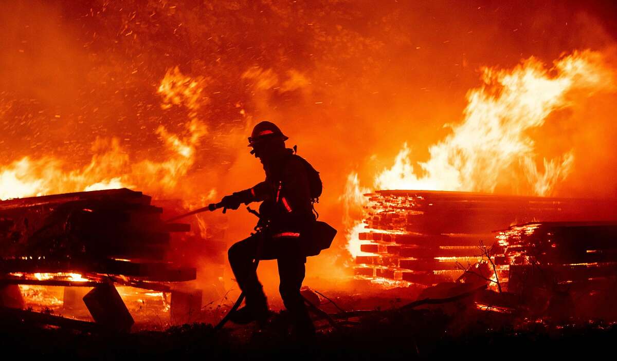 A firefighter douses flames as they push towards homes during the Creek fire in the Cascadel Woods area of unincorporated Madera County, California on September 7, 2020. - A firework at a gender reveal party triggered a wildfire in southern California that has destroyed 7,000 acres (2,800 hectares) and forced many residents to flee their homes, the fire department said Sunday. More than 500 firefighters and four helicopters were battling the El Dorado blaze east of San Bernardino, which started Saturday morning, California Department of Forestry and Fire Protection (Cal Fire) said.