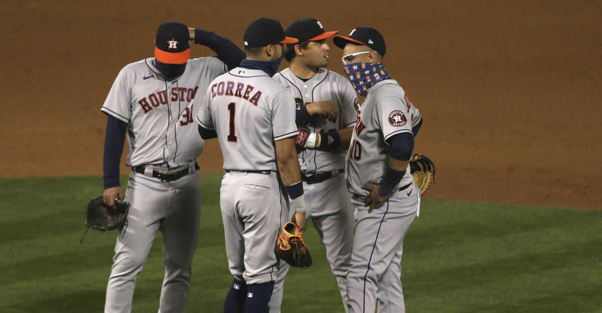 Members of the Houston Astros look on during a pitching change during the seventh inning of a baseball game against the Oakland Athletics in Oakland, Calif., Monday, Sept. 7, 2020. (AP Photo/Jed Jacobsohn)