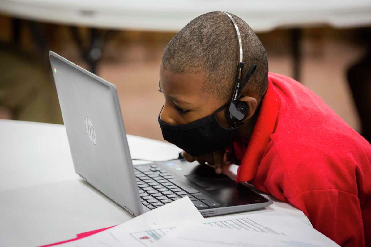 HISD student Cody Wilson focuses on his computer, ignoring the buzzing around him during HISD first day of online classes at Trinity United Methodist Church in Third Ward Tuesday, Sept. 8, 2020, in Houston. The church is providing computer and internet access to students who do not have it at home.
