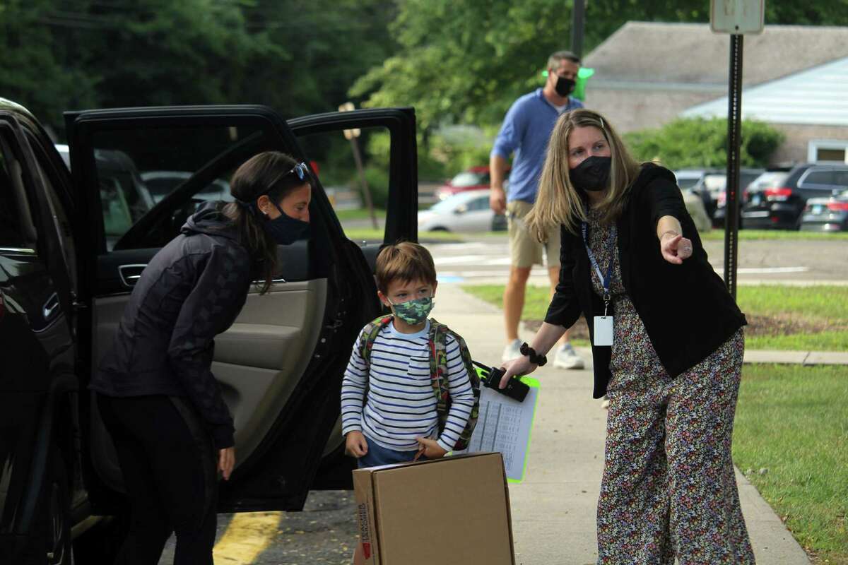 Coleytown Elementary School principal Janna Sirowich assists a family on their first day back at school. Taken Sept. 8, 2020 in Westport, Conn. Sirowich said new students are paired with buddies in school for support and to help with any questions. The school will also host a variety of new family activities throughout the next month, she said. "We're really excited to have all the new families here and all the new students here," Sirowich said. "Coleytown is growing and we're happy about that." Sirowich said parents and staff members set the temperature for the children. "If we are modeling positivity and modeling that we are excited to come back, they feel that," she said.
