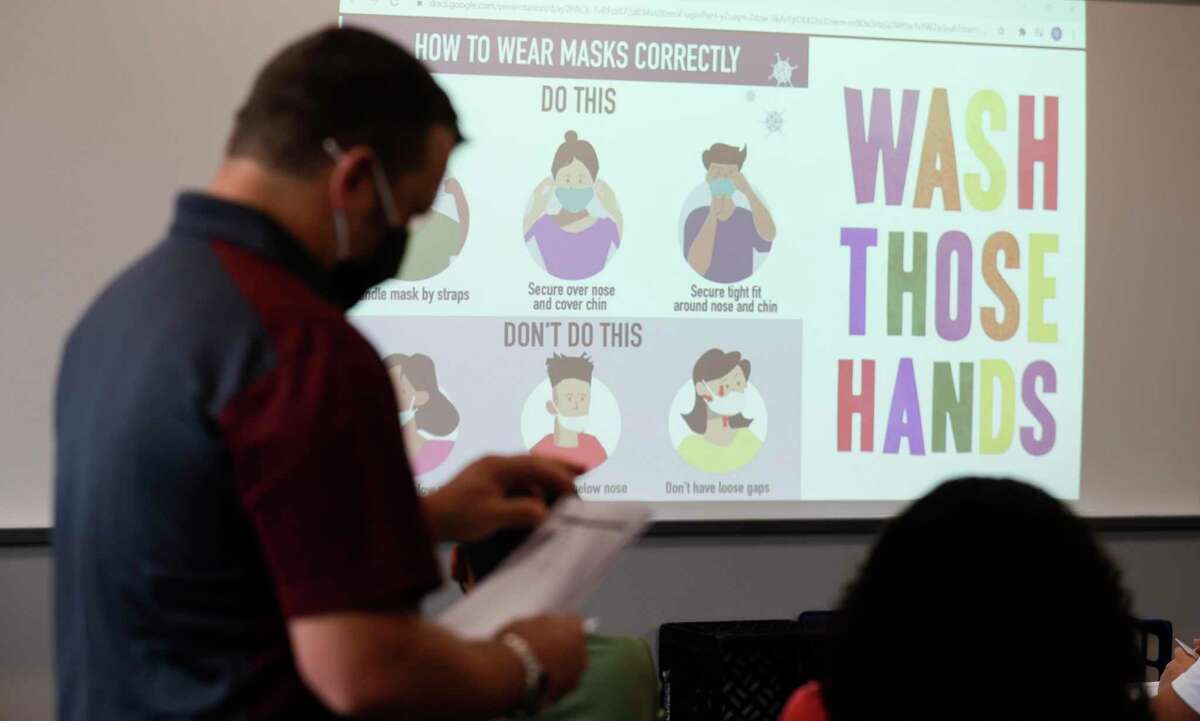 A slide in history teacher Robert Simard’a classroom reminds students how to properly wear their masks and reminds them to wash their hands at Stockton Junior High School on the first day of in-person school for Conroe ISD, Tuesday, Sept. 8, 2020, in Conroe.