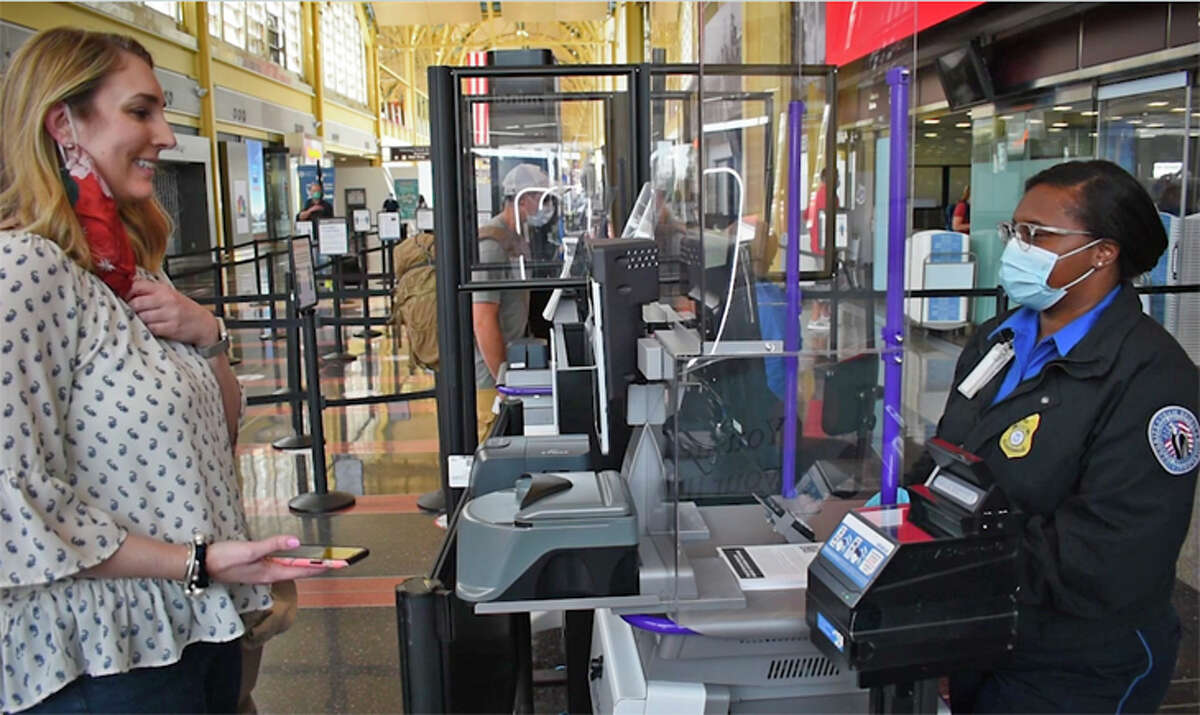 A passenger lowers her face mask for a photo as TSA starts testing facial recognition for domestic travel.