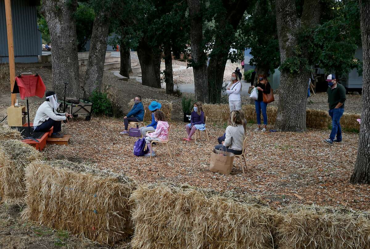Second grade students, with their parents looking on, meet with their teacher on orientation day in their outdoor classroom at Marin Waldorf School in San Rafael, Calif. on Wednesday, Sept. 2, 2020. Faculty and staff will be tested for COVID-19 on a monthly basis by a mobile testing van set up on campus.