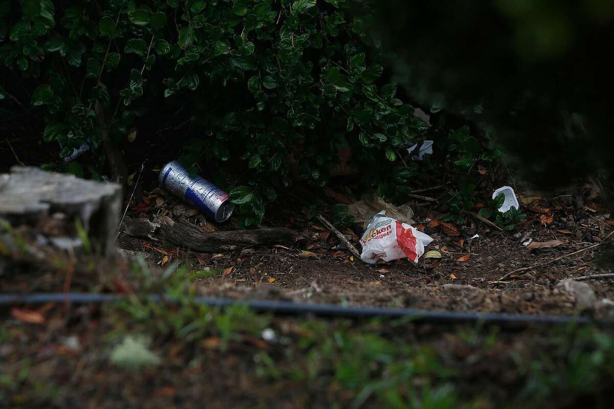 A can and food wrappings are seen along Burnett Avenue near the road closure at Twin Peaks Boulevard and Burnett Avenue on Monday, August 31, 2020 in San Francisco, Calif.