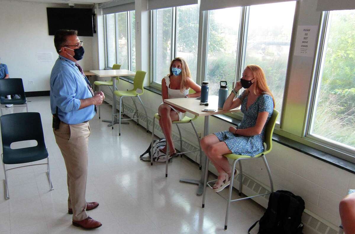 Fairfield Ludlowe High School Headmaster Greg Hatzis chats with seniors Emma Torello and Ellie Melvin, right, during the first day of school for Fairfield Public Schools in Fairfield, Conn., on Tuesday Sept. 8, 2020.