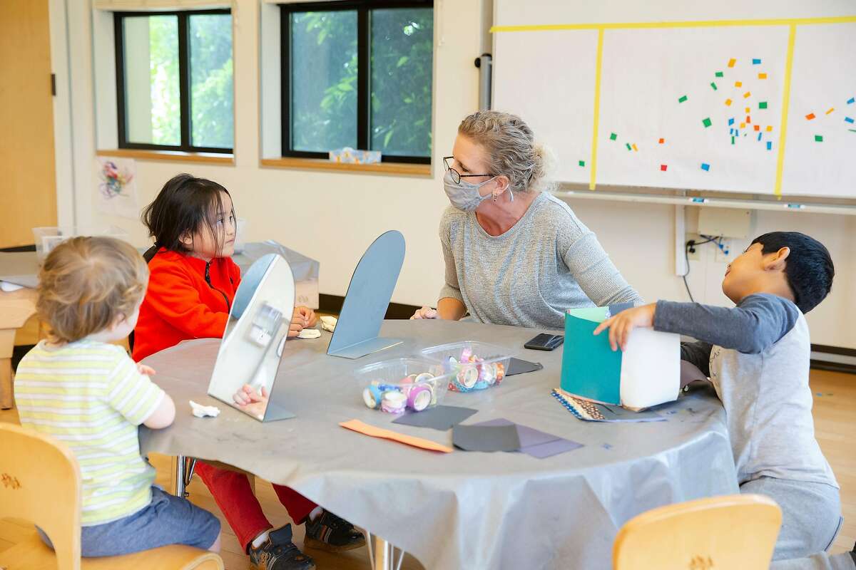 Susan Meyer, a teacher at Holy Family Day Home, works with two kindergarten students, Christopher Ramirez-Ojeda and Andy Beltor during preschool hours at Holy Family Day Home in San Francisco, Calif. on September 3, 2020.