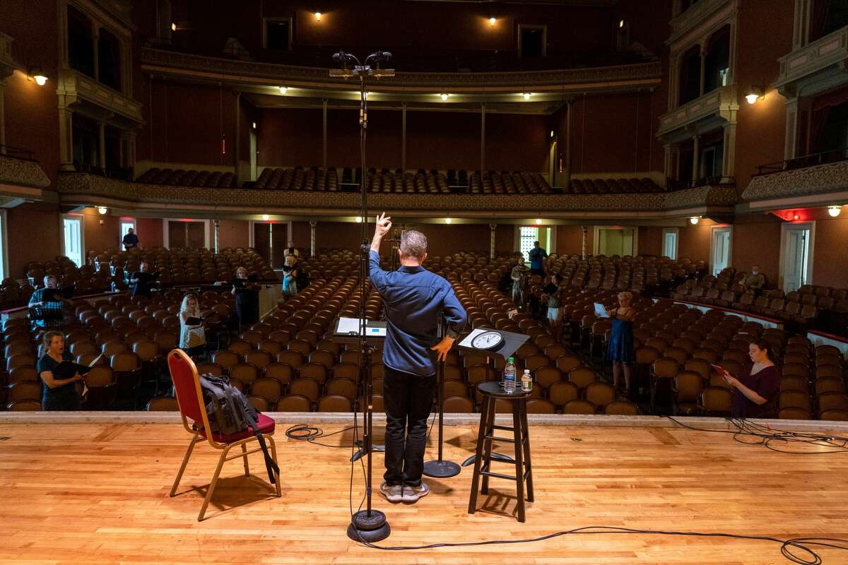 Jose Daniel Flores-Caraballo, artistic director of Albany Pro Musica, conducts members singing in the Troy Savings  Bank Music Hall recently to record music for the group's 40th season, which will be shown on WMHT-TV and online. (Photo by Joe Fazioli for Albany Pro Musica.)