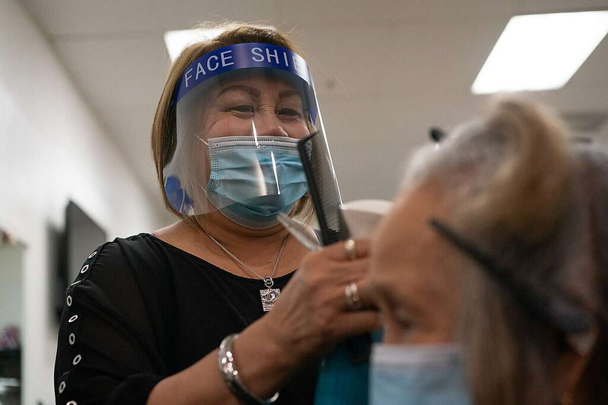 Lita Gabriel owner of Lita's Hair Salon at the Eastridge Center Mall reopens after closing during the coronavirus shutdown on Monday, July 13, 2020 in San Jose, Calif. She is working on the hair of Isabel Agudera, 93.