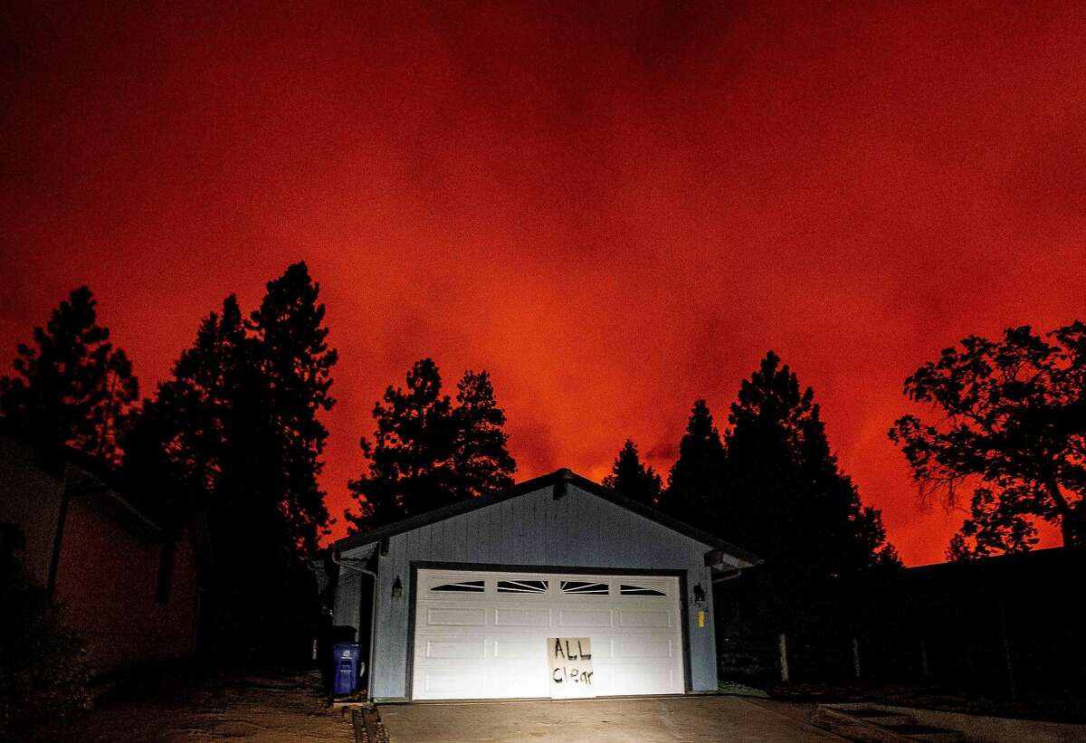 TOPSHOT - A home sits with an "All Clear" sign on the front as fire approaches a neighborhood during the Creek fire in the Tollhouse area of unincorporated Fresno County, California on September 08, 2020. - Fire crews pulled out of the area as multiple erratic columns of fire made its way towards the area. Wildfires in California have torched a record more than two million acres, the state fire department said on September 7, as smoke hampered efforts to airlift dozens of people trapped by an uncontrolled blaze. (Photo by JOSH EDELSON / AFP) (Photo by JOSH EDELSON/AFP via Getty Images)