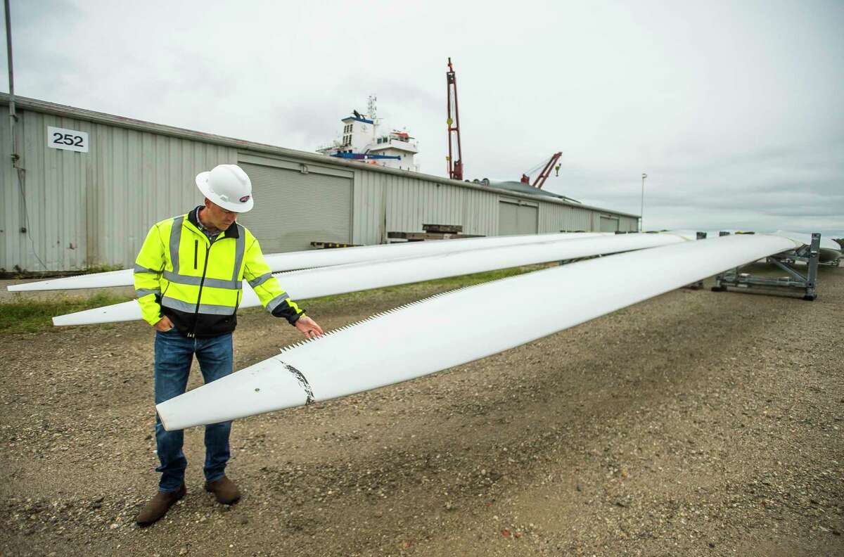 Kevin Cotter of Bay Aggregate, Inc. points out small teeth on the edge of a wind turbine blade before demonstrating the blade's flexibility Tuesday morning at Port Fisher in Bay City. For more photos, visit www.ourmidland.com. (Katy Kildee/kkildee@mdn.net)