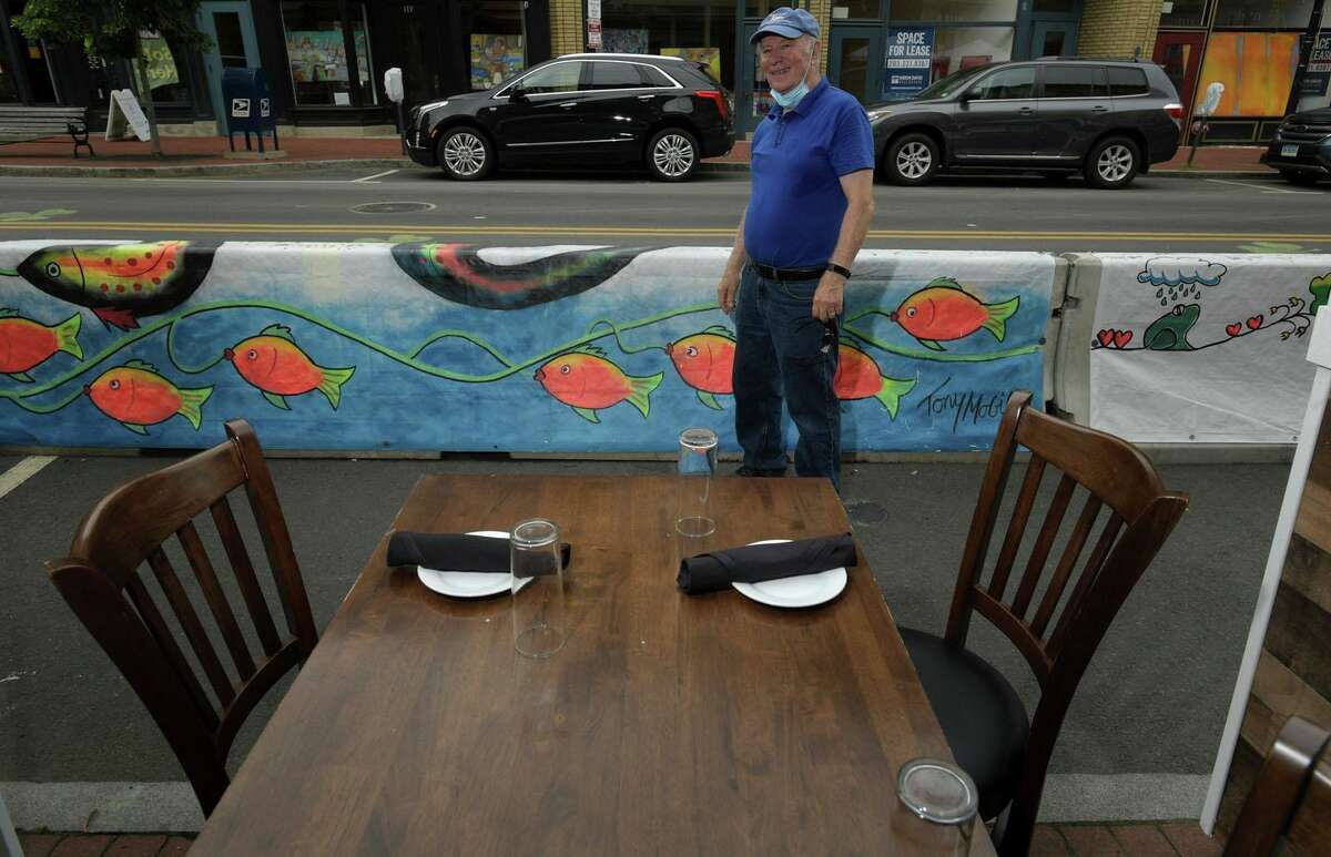 The Norwalk Arts Commission and local artists including Tony Mobilia who painted murals on tarps that now cover concrete barriers on Washington Street meet for the official unveiling on July 23. The barriers were installed to expand outdoor dining space for restaurants during the pandemic, and artists painted murals in the theme of “renewal” for this new outdoor gallery, curated by the Arts Commission.