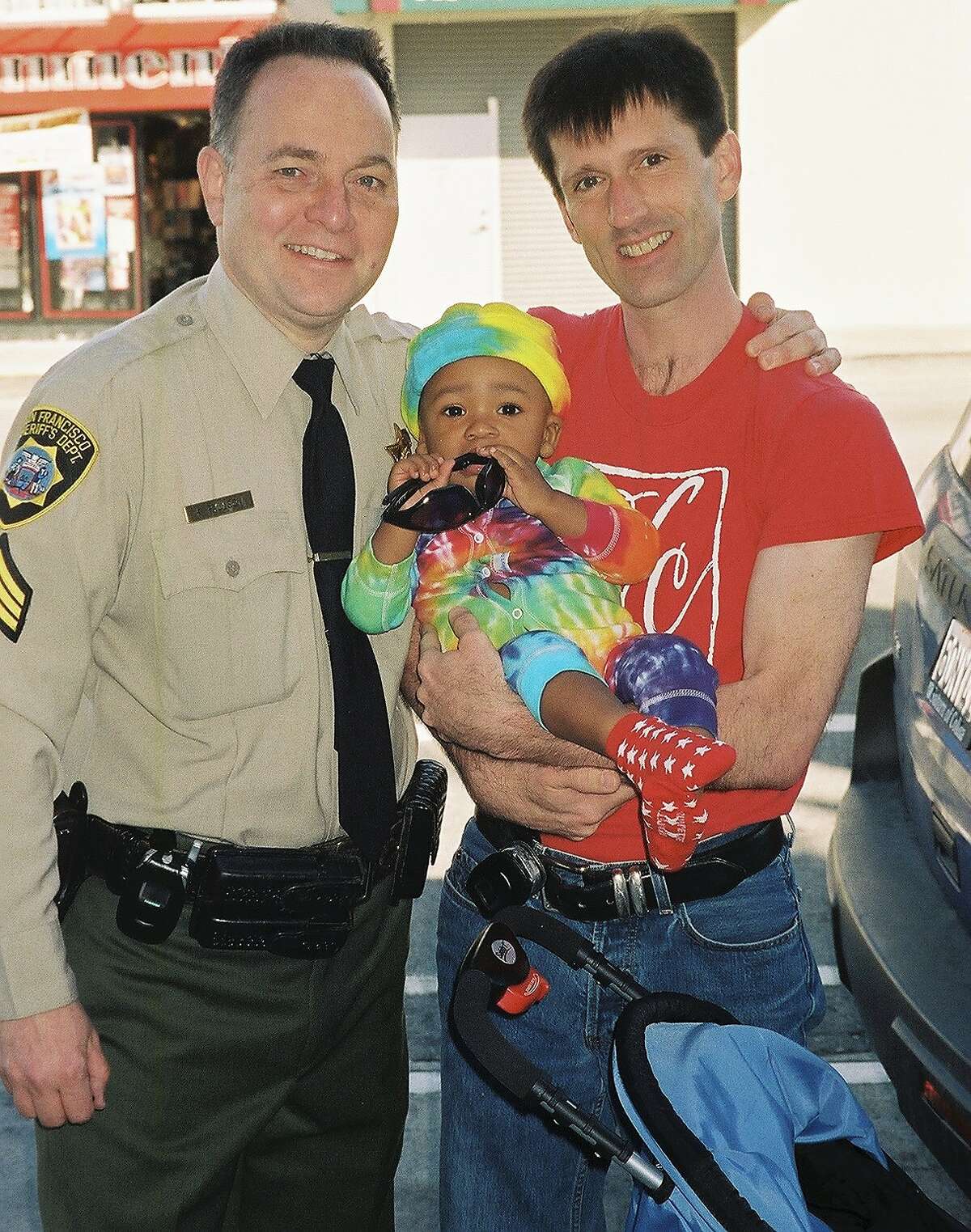 Kevin and Brian Fisher-Paulson pose with their son Zane during San Francisco Pride.
