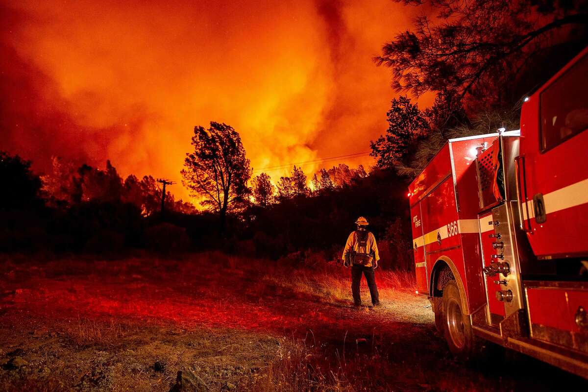Butte county firefighters watch as flames tower over their truck at the Bear fire in Oroville, California on September 9, 2020. - Dangerous dry winds whipped up California's record-breaking wildfires and ignited new blazes, as hundreds were evacuated by helicopter and tens of thousands were plunged into darkness by power outages across the western United States. (Photo by JOSH EDELSON / AFP) (Photo by JOSH EDELSON/AFP via Getty Images)