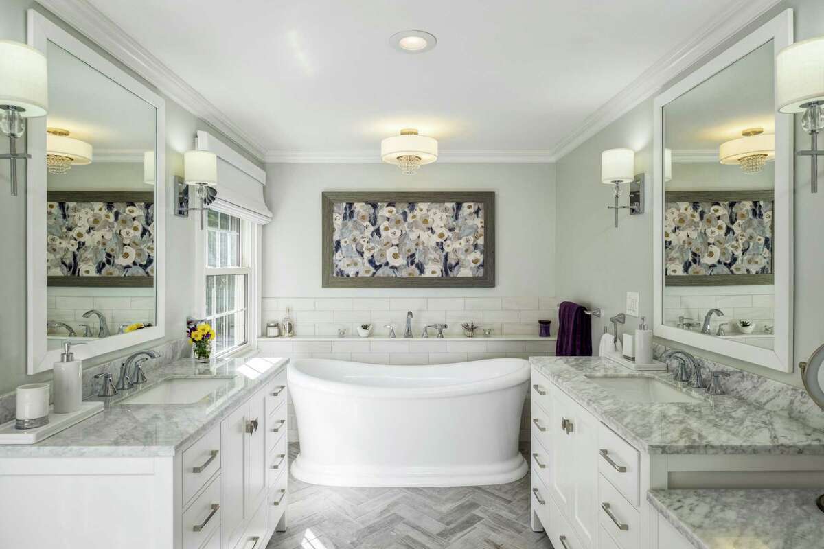 The master bath received an $85,000-plus update including a soaking tub, glass shower, double vanities with quartzite counters and flooring arranged in a herringbone pattern.