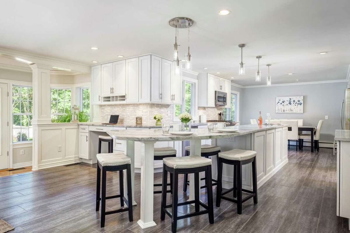 Features in the kitchen, which was renovated in 2014, include a long center island/breakfast bar, an eat-in area, quartzite counters, a marble backsplash, and provides access to the expansive deck.