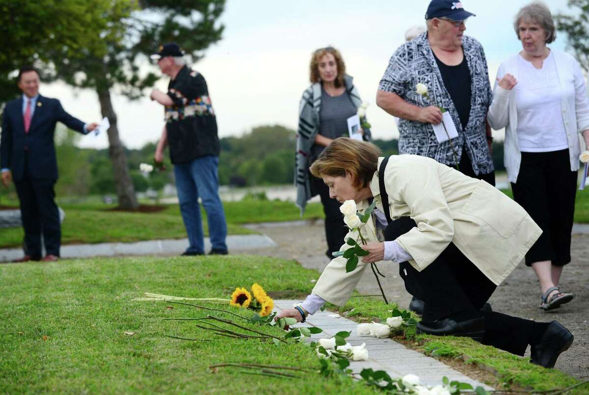 Margot Eckert remembers loved ones at the as she lays roses at the memorial during the State of Connecticut’s 18th annual 9/11 Memorial Ceremony honoring and celebrating the lives of those killed in the September 11, 2001 terrorist attacks Thursday, September 5, 2019, at Sherwood Island State Park in Westport, Conn. Family members of those who were killed in the attacks participated, and the names of the 161 victims with ties to Connecticut were read aloud.