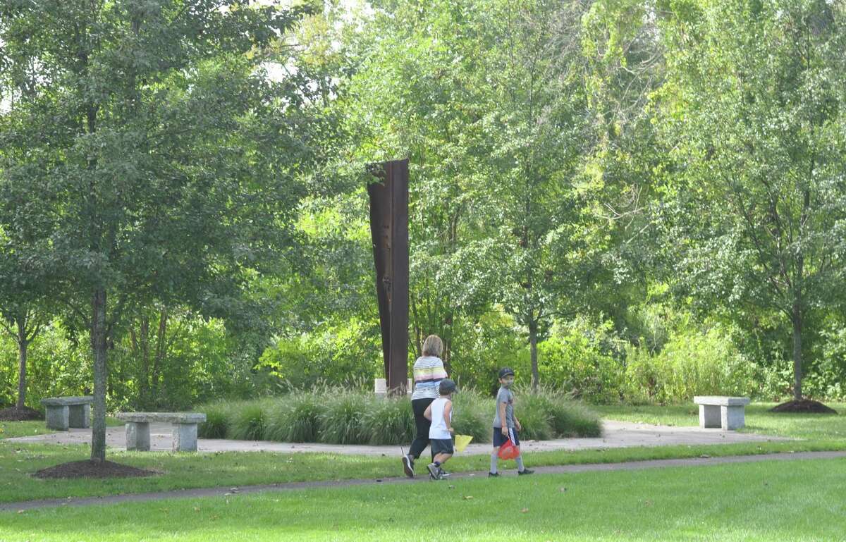 A family on the walking path around the Recreation Center property pass the 9/11 monument on Friday, Sept. 4.