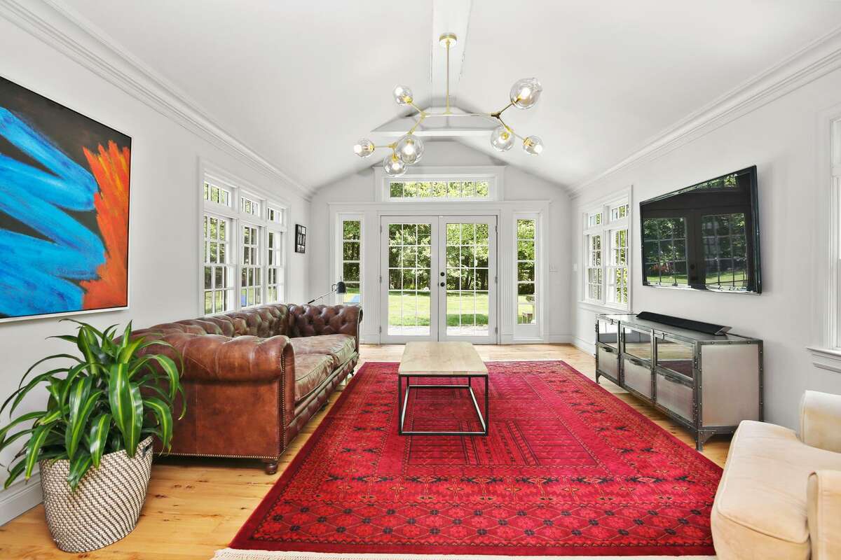 The sunroom has a cathedral ceiling and French doors to the expansive paving stone patio and backyard. This versatile room could also serve as a second home office, if necessary. The living room has a large, multi-pane "walk-in" bay/bow window. In the dining room there is a fireplace and wainscoting framing the lower walls. Its mantel features dentil molding. Off the living room there is a sunroom with a cathedral ceiling and French doors to the expansive paving stone patio and backyard. This versatile room could also serve as a home office.