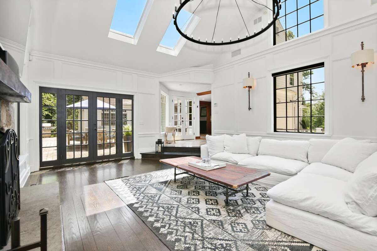 French doors in the family room open to the patio. The chef's kitchen features a center island/breakfast bar, granite counters, Travertine floor, an abundance of cabinets, and high-end appliances, including an over-sized Sub-Zero refrigerator-freezer. There is also a single door to the patio and yard, allowing the home chef a chance to pick fresh vegetables and herbs from the fenced garden to prepare for a family meal. From the kitchen take a few steps down into the family room, which has a tall cathedral ceiling, floor-to-ceiling stone fireplace, a wall of bookshelves, skylights, and French doors to the patio and yard.