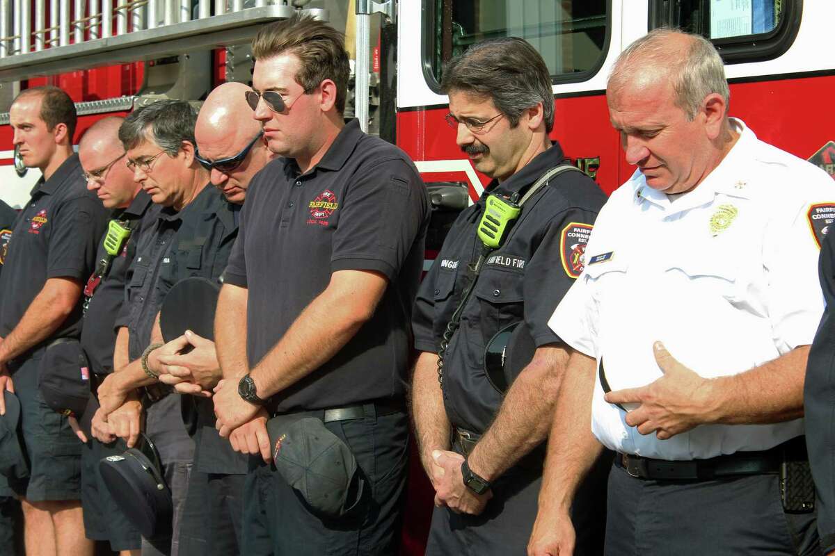 Firefighters bow their heads during a prayer at the town's annual Sept. 11 ceremony Monday at fire headquarters on Reef Road. Fairfield,CT. 9/11/17