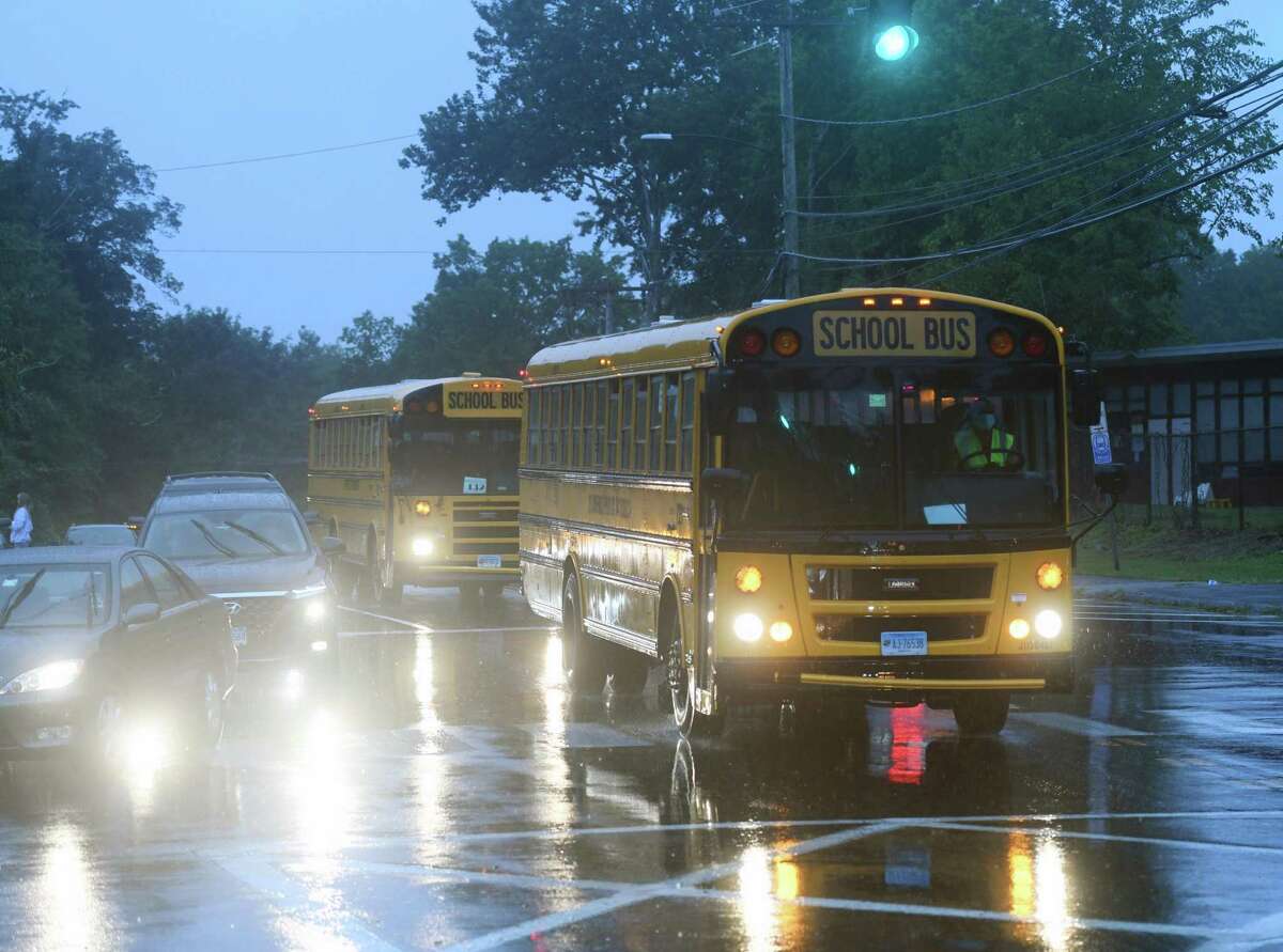 Buses pass by on the first day of the 2020-2021 school year at Westhill High School in Stamford, Conn. Thursday, Sept. 10, 2020. Westhill High School opened two days later than the other Stamford public schools. Teachers at the school bombarded administration with emails late last week saying the school was not ready to open due to issues concerning cleanliness, safety, and teachers not having clear assignments.