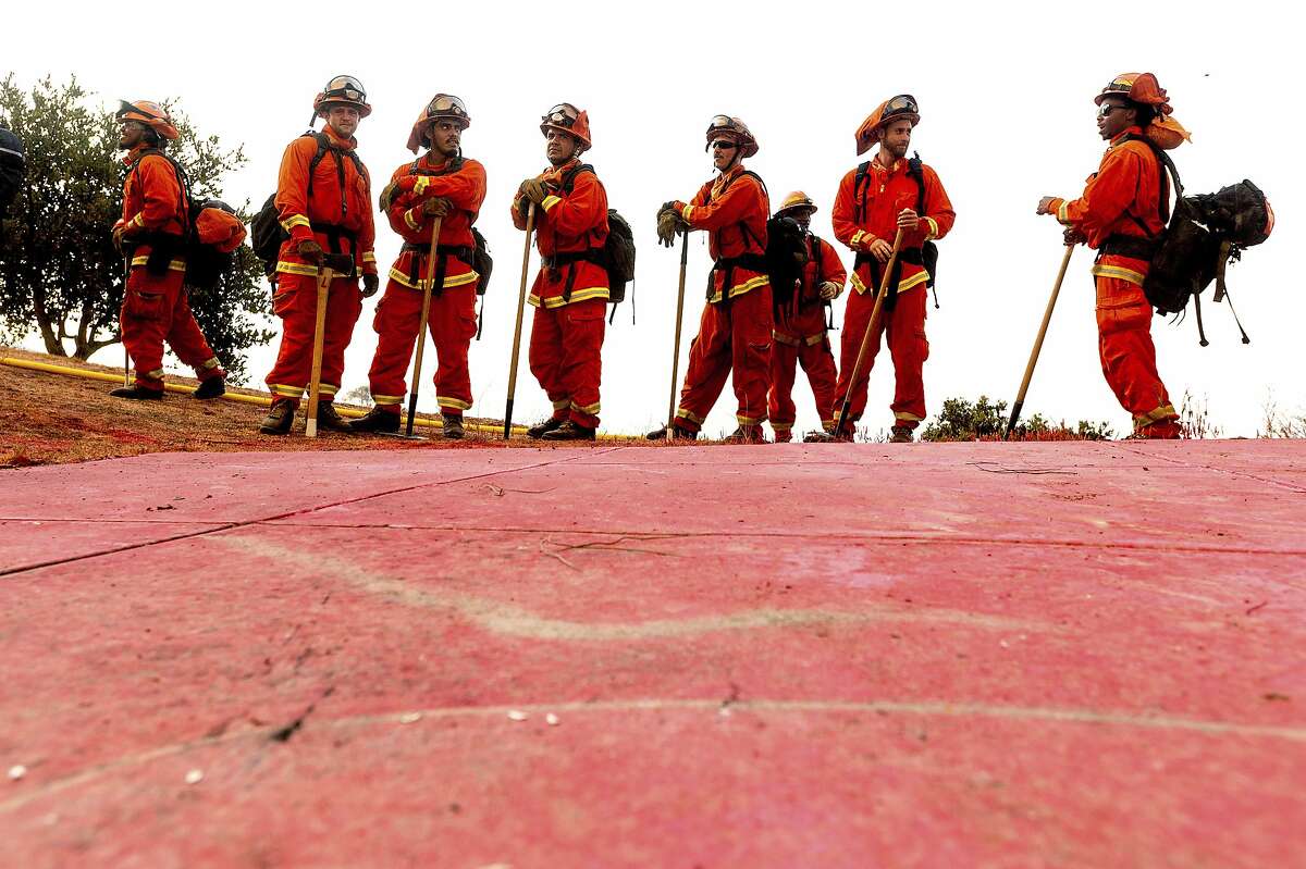Inmate firefighters prepare to take on the River Fire in Salinas, Calif., Monday, Aug. 17, 2020. Fire crews across the region scrambled to contain dozens of blazes sparked by lightning strikes as a statewide heat wave continues. (AP Photo/Noah Berger)