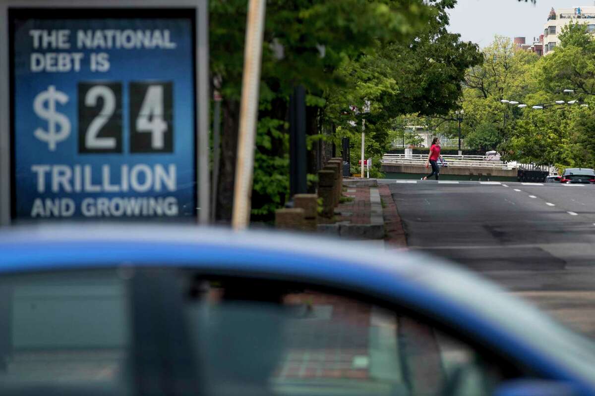 A sign displaying the size of the national debt is displayed along an empty K Street in Washington. The Congressional Budget Office has warned that the government this year will run the largest budget deficit, as a share of the economy, since 1945, the year World War II ended. Next year, the federal debt — made up of the year-after-year gush of annual deficits — is forecast to exceed the size of the entire American economy for the first time since 1946. (AP Photo/Andrew Harnik, File)