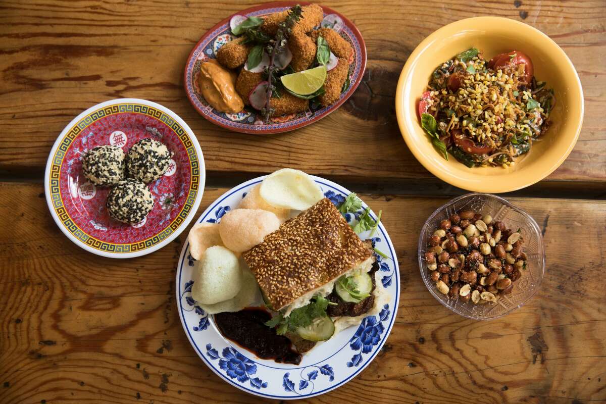 Several of Lion Dance Cafe's signature dishes, including (clockwise from bottom) a shaobing sandwich, A.S.S. cookies, fried tofu nuggets, tomato sour leaf salad and makrut lime peanuts.