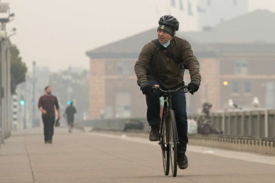 A bicyclist rides along the Embarcadero under smoky, grey skies on Sept. 10, 2020. Photo: Douglas Zimmerman / SFGATE