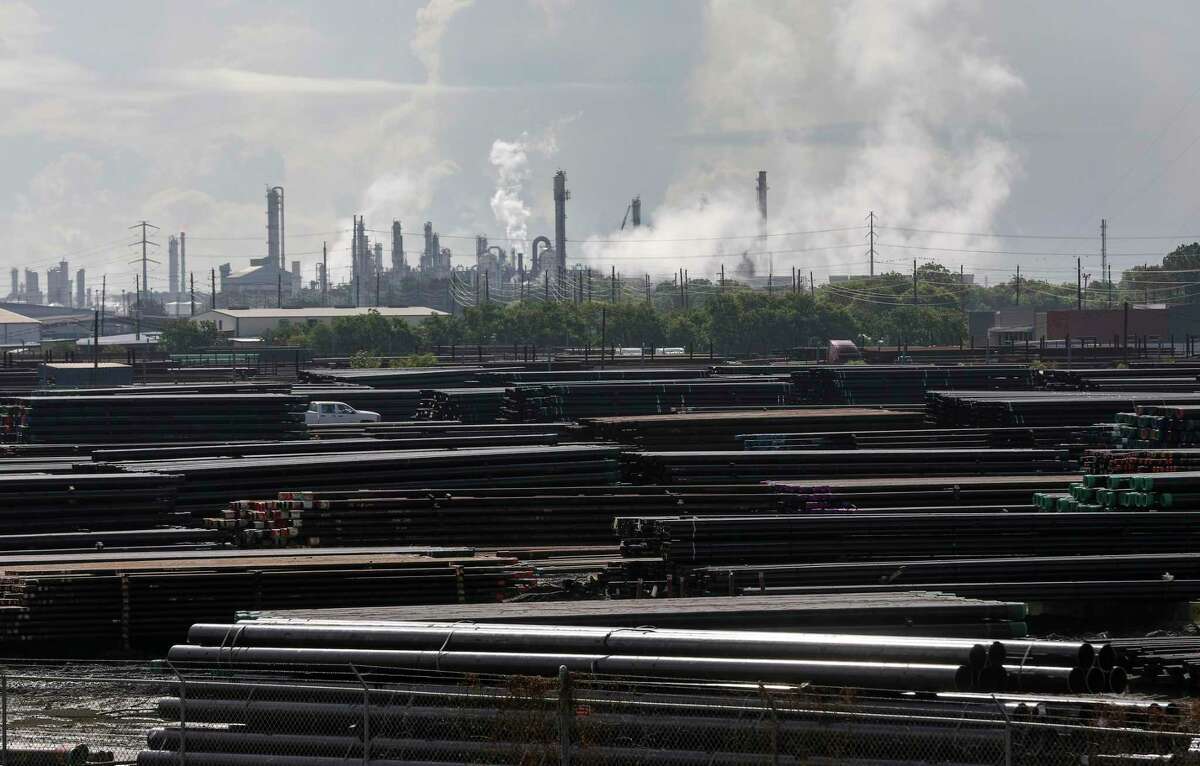 Pipes and a refinery complex, photographed Wednesday, July 22, 2020, in Houston. A societal shift from fossil fuels to renewable energy could force the largest oil companies to sell  $111 billion worth of oil and gas assets in the coming years, according to a new report.