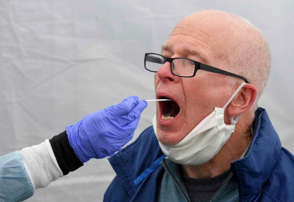 Greenwich resident Larry Heath, 73, is given an Rapid Oral Covid-19 test for the Coronavirus at a testing site at the Family Center at Wilbur Peck Court in Greenwich, on May 1. Growing a culture does offer one nuance that a PCR test doesn’t: A PCR test cannot distinguish between dead and live virus cells. This is important, theoretically, because a person infected with dead virus cells is not contagious, and might not actually need to be quarantined. But, considering how much longer a culture takes to grow (and the fact that the CDC does not suggest growing cultures for safety’s sake), it’s practical to use PCR tests and assume that every viral particle is live. “By the time I come back to you, and tell you, ‘Oh, by the way, two weeks ago I collected a specimen from you and that day showed that you had a live virus. “So, really, you're talking about practicalities,” Rezeq said. You can listen to the full interview with Dr. Rezeq here. (Please note: The transcription is automatic, so there are significant spelling errors).