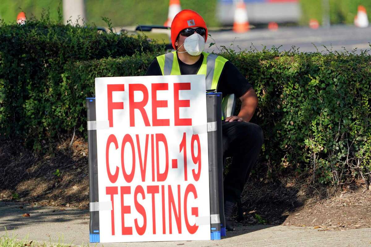 FILE - In this Aug. 19, 2020, file photo, a healthcare worker sits at the entrance to a free COVID-19 testing site at Minute Maid Park in Houston. U.S. health officials have sparked a wave of confusion after posting guidelines that coronavirus testing is not necessary for people who have been in close contact with infected people. (AP Photo/David J. Phillip, File)
