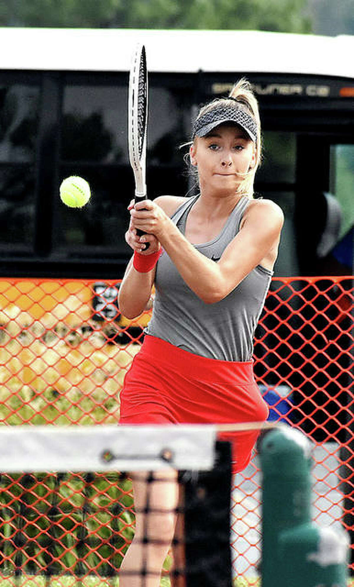 Alton’s Ainsley Fortschneider hits a shot during her No. 1 doubles match against Edwardsville on Friday at the EHS Tennis Center.