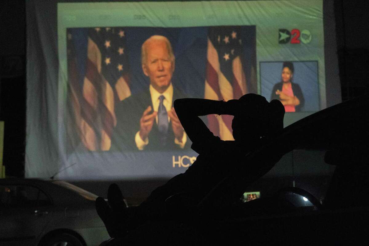 HOUSTON, TX - AUGUST 20: A Joe Biden supporter watch DNC as Joe Biden appears on a large screen during a drive-in DNC watch event on August 20, 2020 in Houston, Texas. The convention, which was once expected to draw 50,000 people to Milwaukee, Wisconsin, is now taking place virtually due to the coronavirus pandemic.
