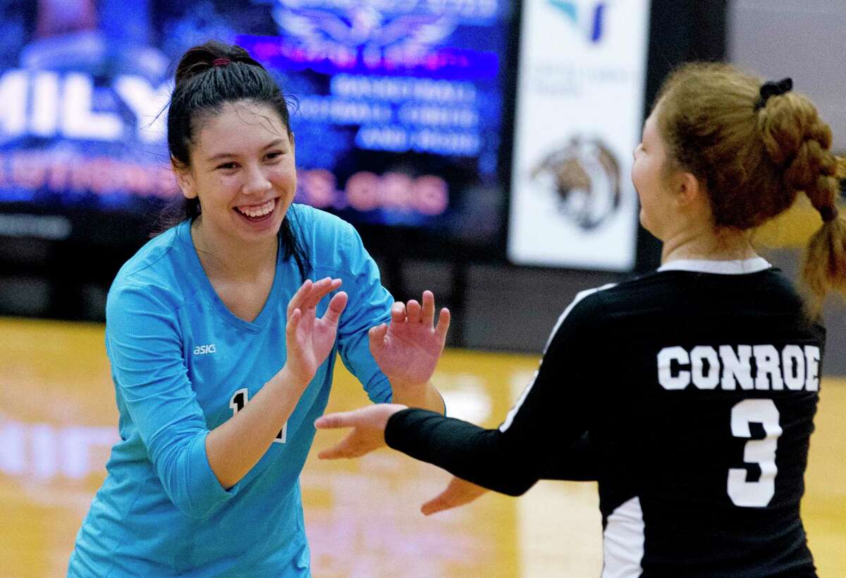 Conroe libero Saege Anzueto (12) shares a laugh with right side hitter Amanda Rivera (3) in the second set of a non-district high school volleyball match at Conroe High School, Tuesday, Aug. 13, 2019, in Conroe.