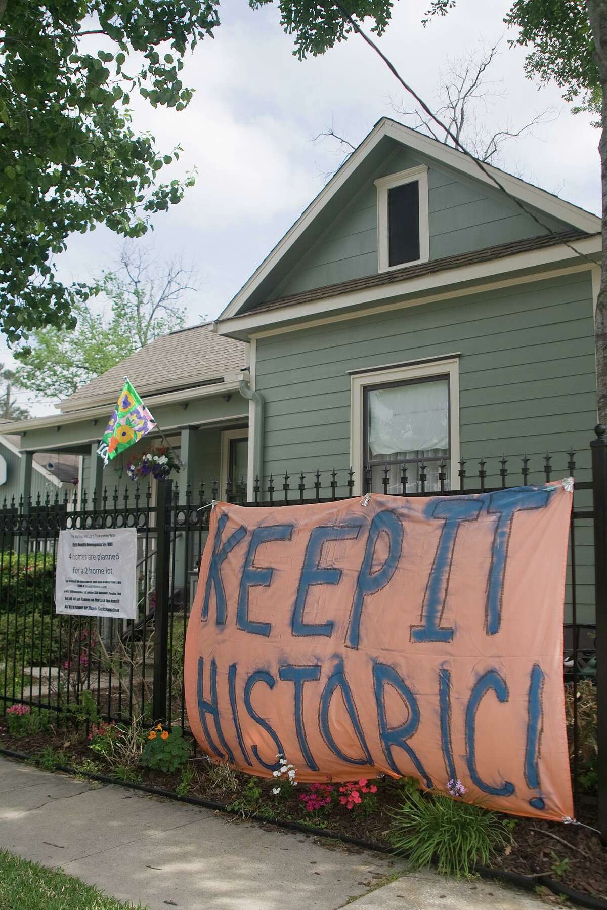 Signs protesting the proposed construction of 4 homes on a double-sized lot at 15th and Rutledge in the Heights Historic District are attached to walls, fences, and stands around the area. Photo by R. Clayton McKee