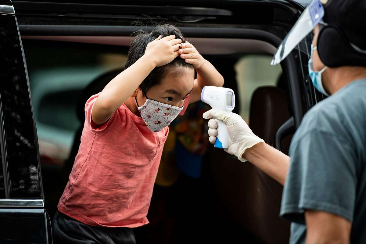 A student has his temperature taken as he arrives at STAR Eco Station Tutoring & Enrichment Center on Sept. 10 in Culver City (Los Angeles County).