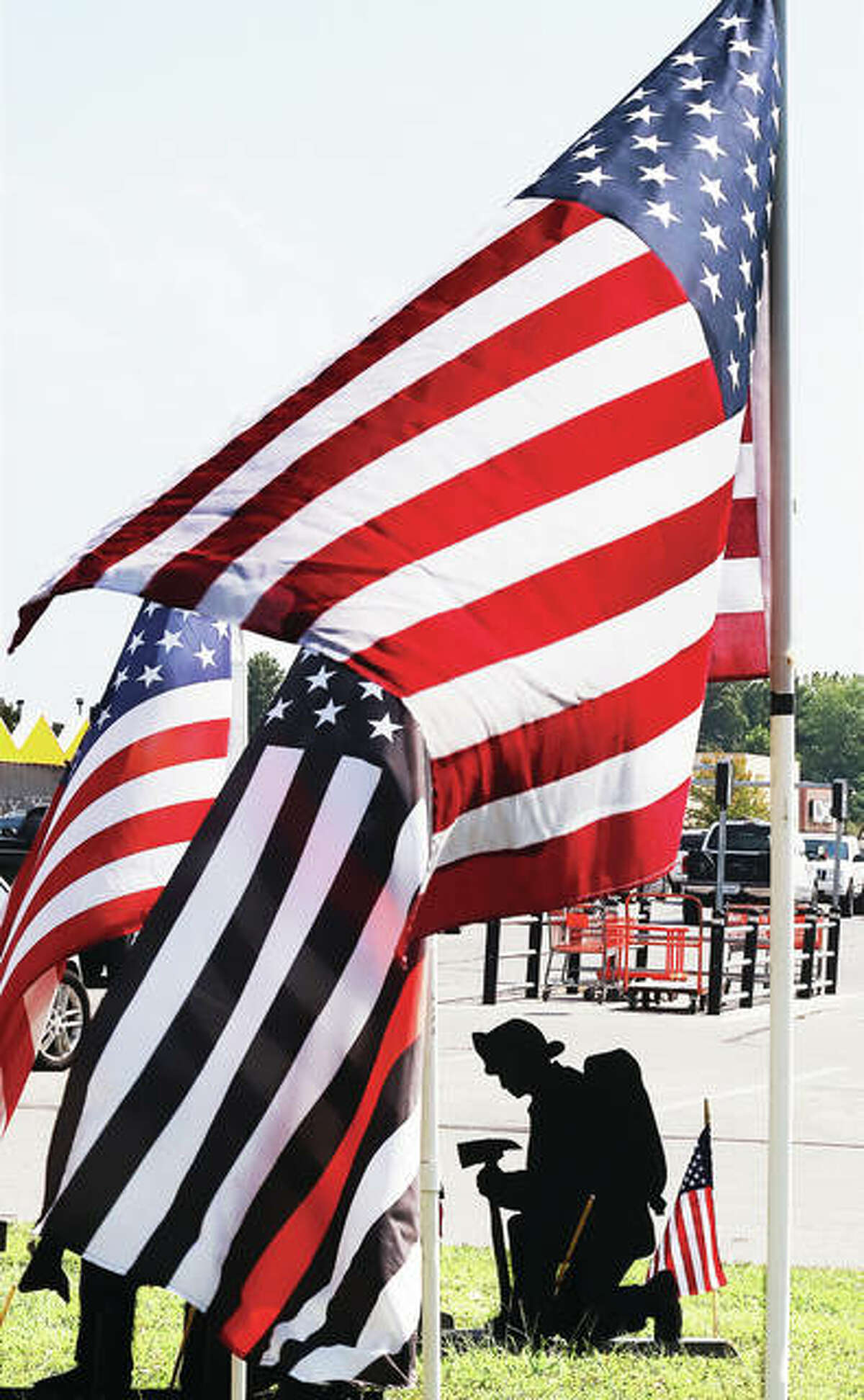A display of flags and silhouettes is setup at the edge of the parking lot at the Alton Home Depot to honor those who died in the terrorist attacks on the United States 19 years ago Friday. Of the 2,977 people who died in the three attacks, 343 were firefighters.