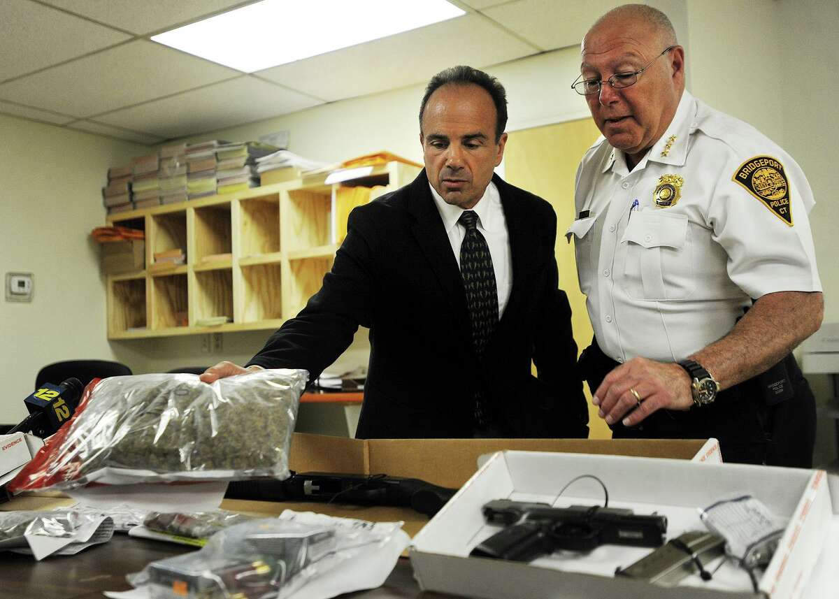 Bridgeport Mayor Joe Ganim and Police Chief A.J. Perez show heroin, marijuana, guns, and cash seized following the arrest of three men, including Black Rock resident Joel Jean, Wednesday evening. Jean is suspected of distributing heroin throughout the city of Bridgeport as well as the towns of lower Fairfield County. The Darien Police Department Selective Enforcement Unit worked with the Bridgeport Narcotics Task Force on the investigation.