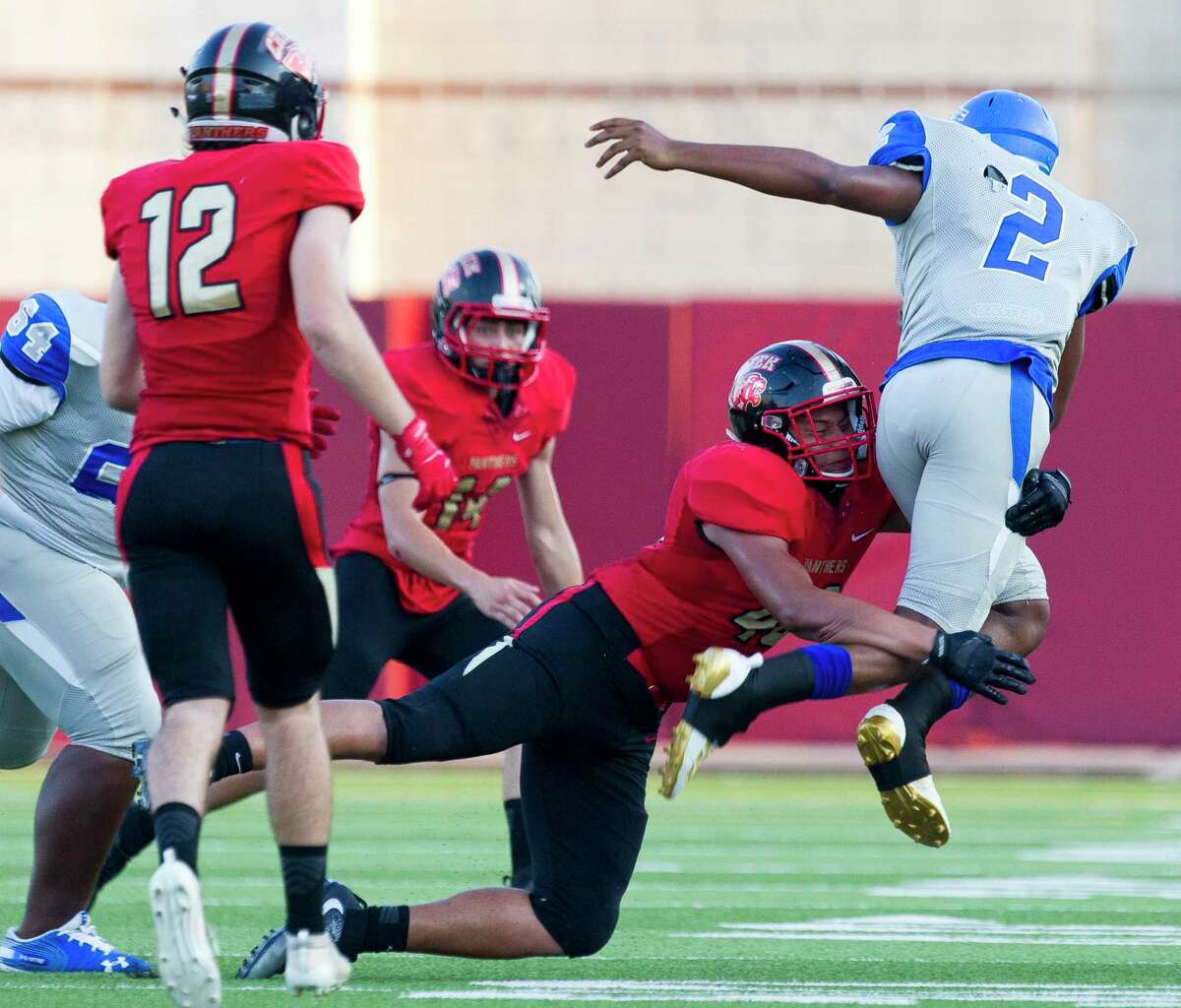 Caney Creek defensive linemen Edgar Heredia (46) tackles Pro-Vision Academy quarterback Trajon Duhart (2) in midair during the first quarter of a non-district high school football game at Woodforest Bank Stadium, Thursday, Sept. 5, 2019, in Shenandoah.
