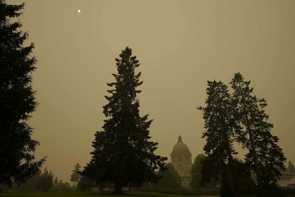 Smoke from wildfires in Oregon and California creates hazy skies as the sun is seen above the Washington state Capitol, Saturday afternoon, Sept. 12, 2020, in Olympia, Wash. Numerous air quality warnings were in place for most of the West through the weekend. (AP Photo/Ted S. Warren)