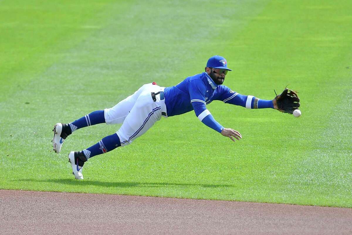 Toronto Blue Jays' second baseman Jonathan Villar dives for a ball hit for a single by New York Mets' Jeff McNeil during the first inning of a baseball game in Buffalo, N.Y., Sunday, Sept. 13, 2020. (AP Photo/Adrian Kraus)