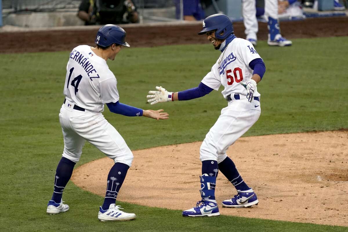 Los Angeles Dodgers' Mookie Betts, right, gets congratulations from Enrique Hernandez, after Betts hits a two-run home run against the Houston Astros during the fifth inning of a baseball game in Los Angeles, Sunday, Sept. 13, 2020. (AP Photo/Alex Gallardo)