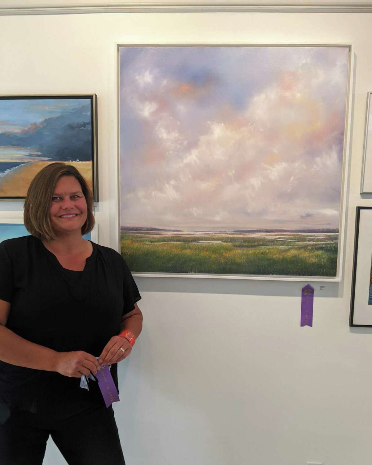 Rowayton Arts Center gallery in Norwalk is hosting the “Marine & Coastal Art” exhibition through Oct. 10. Pictured is Best in Show winner Kris Toohey, with her oil painting “Skyscape.”