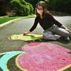 Ariel Langberg, 16, of Ridgefield, uses chalk to draw an apple and pot of honey, symbols of Rosh Hashana, outside the entrance of Temple B'Nai Chaim. The chalk drawing was the inaugural event of the temple’s youth group, kicking off the High Holy Days.