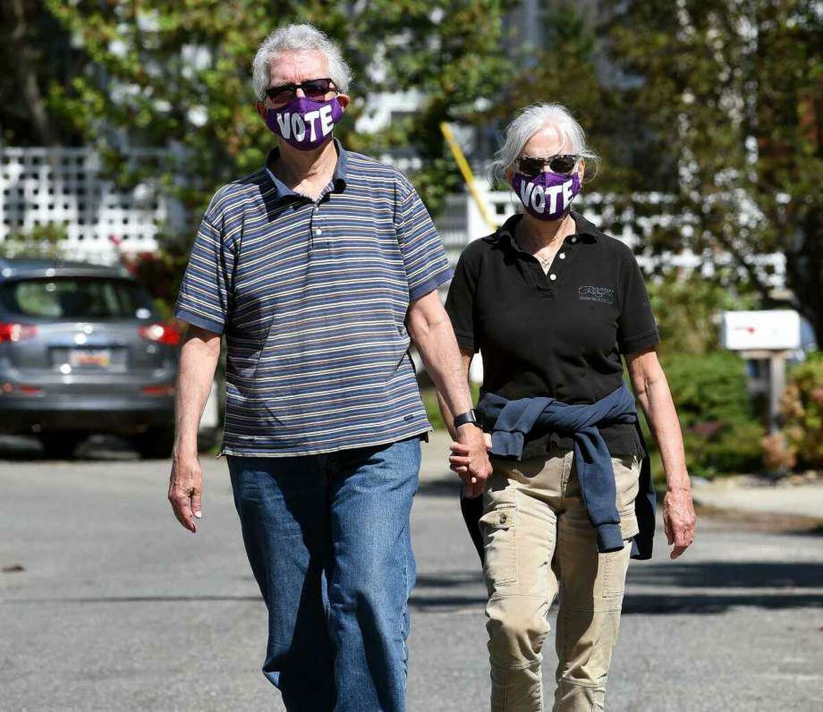 Don Schopiek (left) and his wife, Laurie, take a weekend walk in the Fort Trumbull Beach area of Milford wearing their VOTE face masks on September 12, 2020.