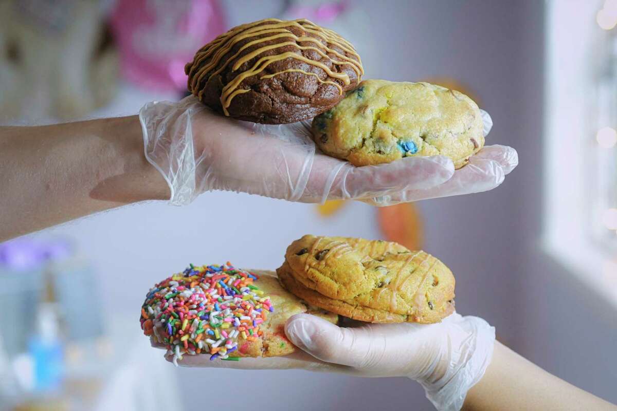 Husband and wife, Rob and Alicia Jansen hold a chocolate peanut butter cookie, a chocolate chip M&M, a pumpkin espresso cookie, and a rainbow sprinkle sugar cookie at their store,Upstate Cookie Shack, on Monday, Sept. 14, 2020, in Rensselaer, N.Y. (Paul Buckowski/Times Union)
